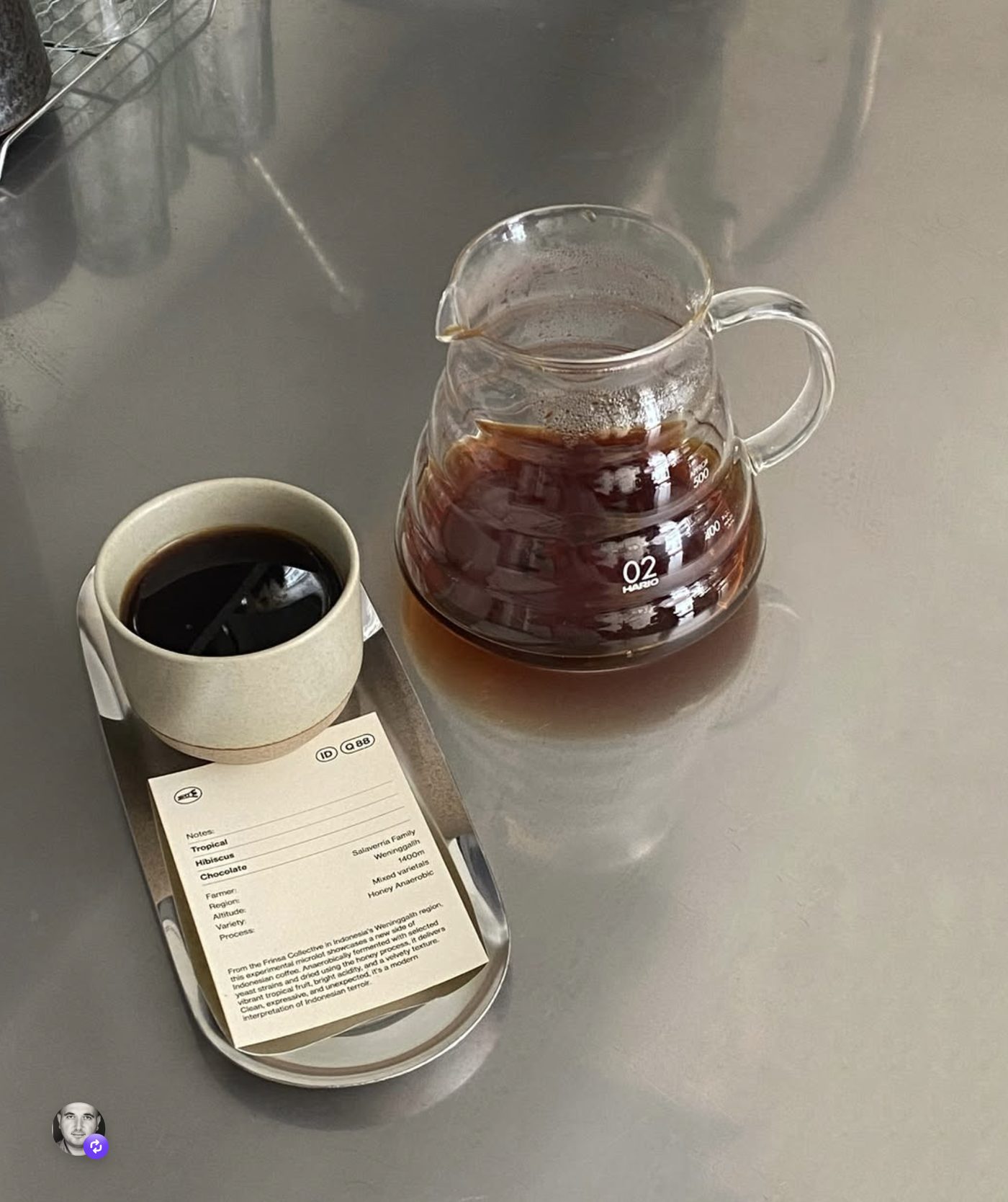 A pour-over and a cup on the counter, tasting card alongside